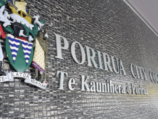 Porirua City Council building wall with crest and bilingual signage.