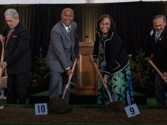 Group of dignitaries turning soil with shovels at the Wellington New Zealand Temple groundbreaking ceremony.