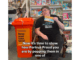 Porirua Deputy Electoral Officer Jack Marshall sitting beside a bright orange ballot drop box in a library, holding a voting envelope. Text on screen reads: “Now it's time to show how Porirua Proud you are by popping them in one of...”