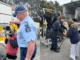 Two children interacting with New Zealand Police Dive Squad officers and trying on diving equipment during a holiday event.