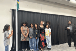People sing next to a raised Solomon Islands flag at a cultural ceremony in Porirua.