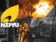 Two firefighters in yellow protective gear spray water on a house fire at night as flames and smoke rise behind trees, with the NZPFU logo displayed in the corner.