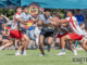 Paremata-Plimmerton player is tackled by multiple Hutt Old Boys Marist defenders during the National Club Sevens at Ngāti Toa Domain.