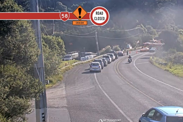 Alt text: Traffic queues on State Highway 58 near Belmont Rd as emergency services respond to a serious crash and road closure.