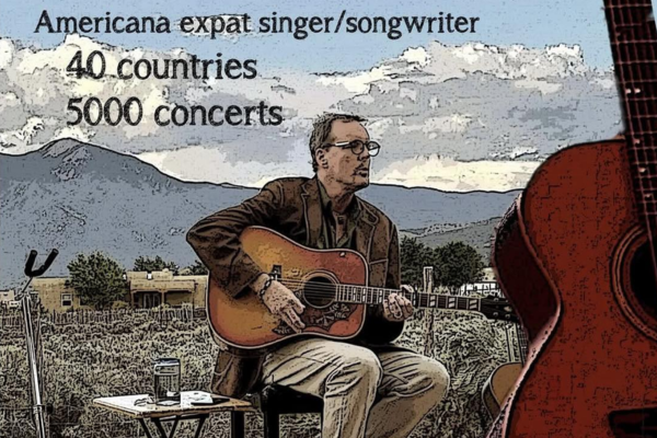 Brett Perkins sits outdoors playing an acoustic guitar, with mountains in the background and text highlighting his international touring career.