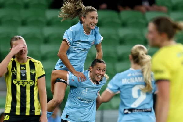 Melbourne City players celebrate during the Ninja A-League Women grand final against Wellington Phoenix at AAMI Park, while Phoenix players react after conceding a goal.