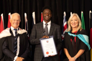 Ethan Mupariwa holds his Wellington College Courtney O’Connor Scholarship certificate at the International College of Management, Sydney scholarship ceremony.