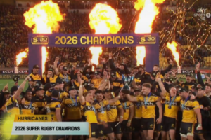 Hurricanes players celebrate under flames and confetti after being crowned 2026 Super Rugby champions.