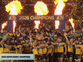 Hurricanes players celebrate under flames and confetti after being crowned 2026 Super Rugby champions.