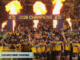 Hurricanes players celebrate under flames and confetti after being crowned 2026 Super Rugby champions.