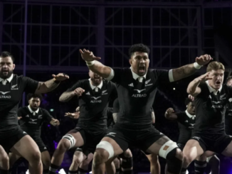 Alt text: All Blacks players perform the haka in black jerseys before a rugby match.