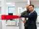 Wellington Blood Bank team leader Dan Gyles holds a red ribbon as Health Minister Simeon Brown cuts it at the new Wellington Blood Bank.