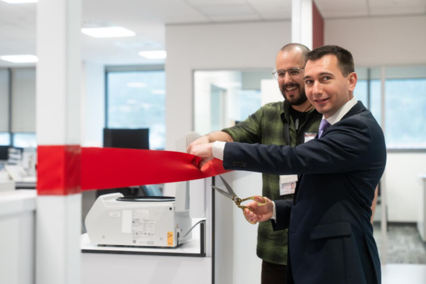 Wellington Blood Bank team leader Dan Gyles holds a red ribbon as Health Minister Simeon Brown cuts it at the new Wellington Blood Bank.