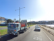 Traffic travelling along Cobham Drive in Wellington, with a roadworks truck carrying traffic cones in the foreground.