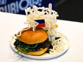Lazy Juan’s Marites burger, winner of Burger Wellington 2026, topped with a Philippine flag and served with crispy rice noodles.