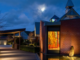 Our Lady’s Home of Compassion in Island Bay at dusk, with an illuminated stained-glass artwork by John Drawbridge visible in the chapel.