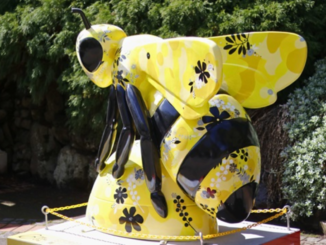 Yellow and black giant bee sculpture decorated with floral patterns in the Wellington Botanic Garden.