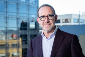 Wellington Mayor Andrew Little standing outside a modern office building.