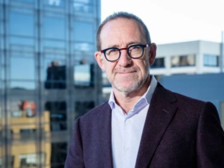Wellington Mayor Andrew Little standing outside a modern office building.
