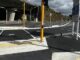 A signal-controlled crossing with yellow poles and tactile paving on Hutt Road beside a concrete viaduct.